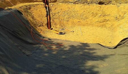 Výkopové práce na koupacím jezírku s těžkou technikou