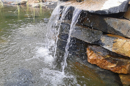 Vodopád padající do zahradního jezírka u terasy
